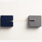Due blocchi geometrici distinti, uno blu scuro e uno grigio, posizionati su uno sfondo chiaro e attraversati da una sottile linea metallica dorata.